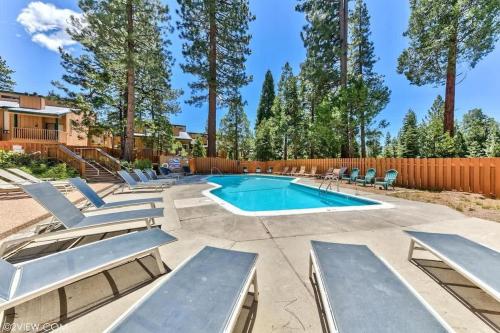 a swimming pool with lounge chairs and a fence at #LazyBear Tahoe Dreamy Escape in Tahoe Vista