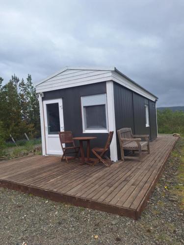 a cabin with a table and chairs on a wooden deck at Sólvellir Holiday Home in Kjósahreppur