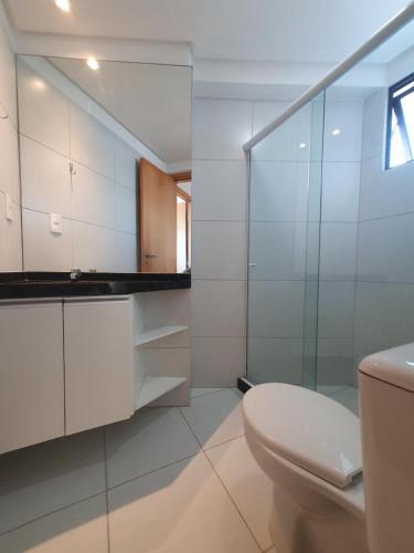 a bathroom with a toilet and a glass shower at Flat Rosarinho Essence in Recife