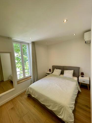 une chambre avec un lit et une grande fenêtre dans l'établissement T3 Lumineux & Cosy avec Balcon Escapade by DarBonne, à Narbonne