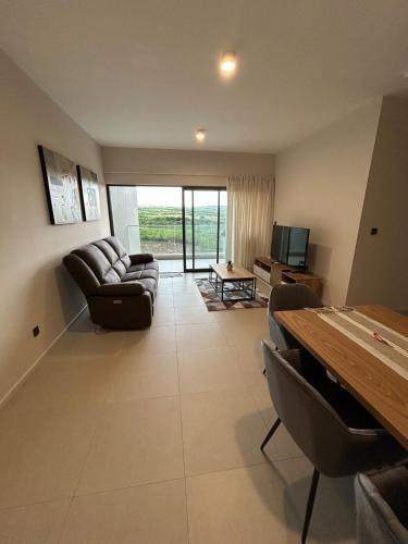 a living room with a couch and a table at La Marquise sky two rooms apartment in Moka
