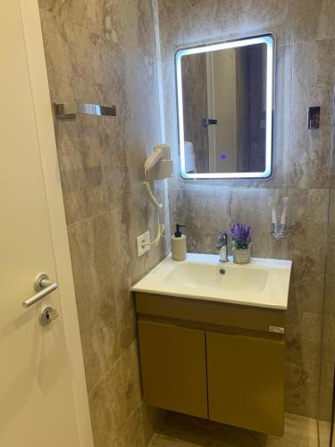 a bathroom with a sink and a mirror at Tirana Magnifique Apartments in Tirane