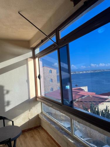 a room with a large window with a view of the water at F2 Meublé à Louer à Side Fradj À 2 pas de la plage ! in Staoueli