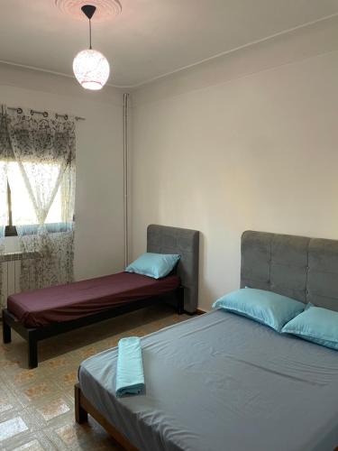 a bedroom with two beds and a couch and a window at F2 Meublé à Louer à Side Fradj À 2 pas de la plage ! in Staoueli