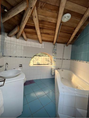 a bathroom with a sink and a bath tub at Illa Wasi Sacred Valley in Urubamba
