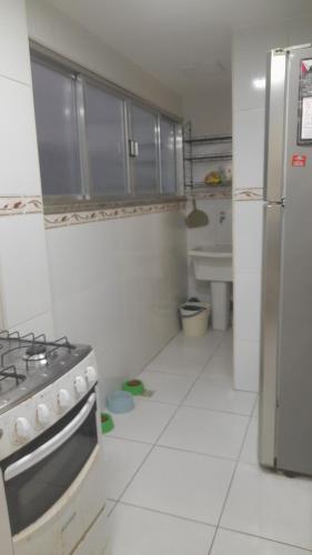 卡波布里奥Lindo apartamento de frente a praia do forte cabo frio的配有炉灶和冰箱的厨房