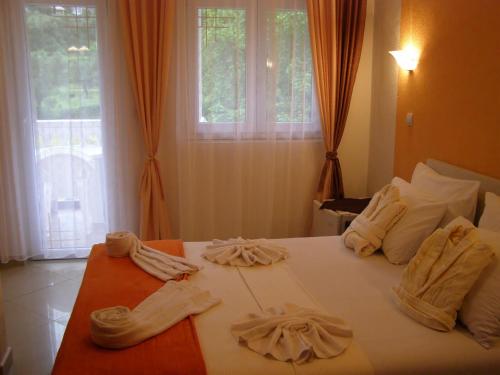 1 dormitorio con 1 cama con toallas en Hotel Wellness & Spa Angelo Gabriel, en Petrovac na Moru