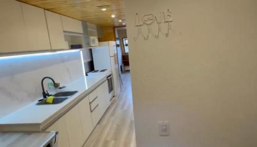 a kitchen with white cabinets and a sink at Departamento en Edificio Atenas con excelentes Vistas in Las Lenas