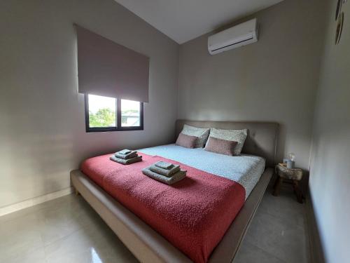 a bedroom with a large bed with a red blanket at Parakreek Apartments in Boxel