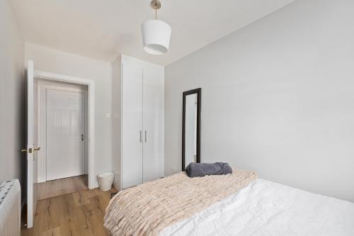 a white bedroom with a bed and a mirror at South Dublin Oasis in Dublin