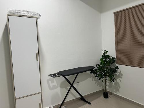 a black stool in a room with a plant at Opening promo Taman Seri Lalang Kluang in Kluang