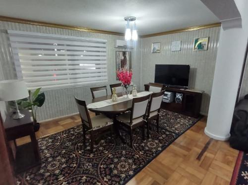 une salle à manger avec une table, des chaises et une télévision dans l'établissement Departamentos Turisticos Osorno Alquiler, à Osorno