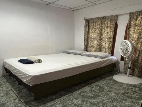 a bedroom with a large bed with a fan at Casa Robles - Your Stay Near Airport in Managua