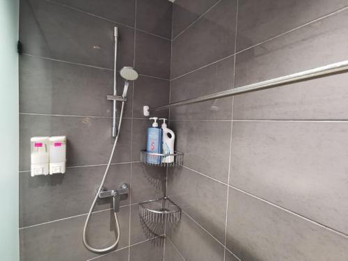 a bathroom with a shower with a blow dryer on the wall at SwissBelResidence Studio With King Bed in Kuantan