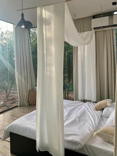 a bedroom with a bed with white sheets and a window at منتجع سفاري ديور in At Turbīyah