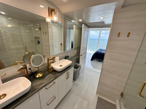 a bathroom with a sink and a mirror at Ocean Front on Fort Lauderdale Beach 2 br Condo Apartment in Fort Lauderdale