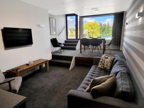 a living room with a couch and a tv and a table at Heart of Queenstown in Queenstown
