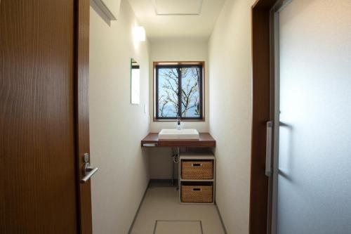 a small bathroom with a sink and a window at Iso Ocean Breeze Villa in Kyotango