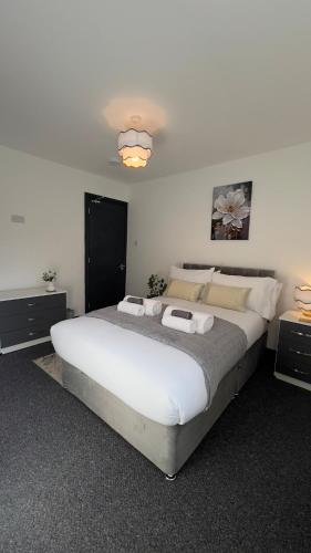 a bedroom with a large white bed with two night stands at Grace home by Esongrace stays in Stoke on Trent