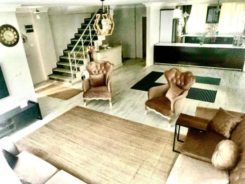 a living room with a couch and chairs and a staircase at Ahmet Teacher's villa is 6 minutes from Istanbul airport in Arnavutköy