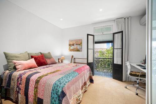 a bedroom with a bed and a desk and a window at Stylish Fully Renovated Luxe 3BR, 2BA Balmain Terrace near Parks, Ferry, Cafes & Pubs in Sydney