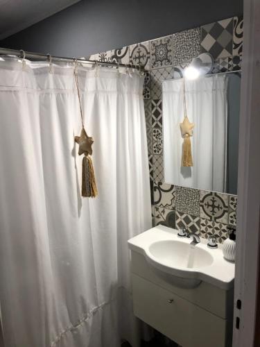 een badkamer met een douchegordijn en een wastafel bij Quinta Mi Quincho in San Pedro