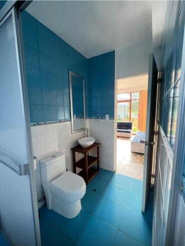 a blue bathroom with a toilet and a sink at Lofts Illawasi in Urubamba