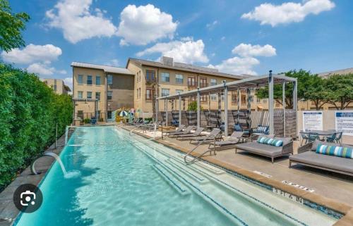 a swimming pool at a resort with lounge chairs at Cozy 1,100sf apartment in the heart of Legacy in Plano