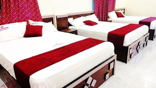 a group of three beds in a room at Hotel SONIA MAHI INN KANYAKUMARI in Kanyakumari