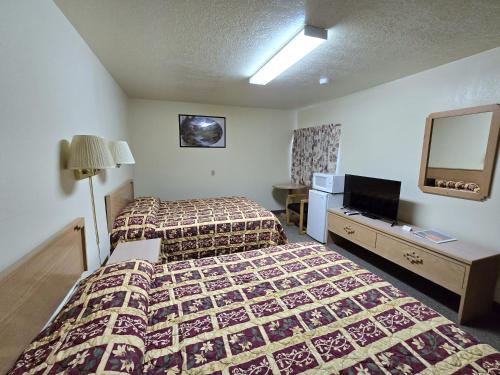 a hotel room with two beds and a television at Dove Creek Inn in Dove Creek
