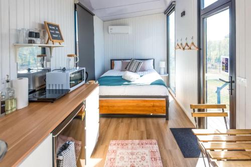a small bedroom with a bed and a desk at Black Horse Cabin 2 by Tiny Away in Parakakau