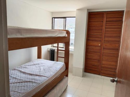 a room with two bunk beds and a window at PH1 Plaza 3 Rodadero in Santa Marta