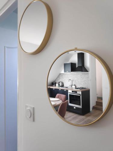 un miroir accroché au mur dans une cuisine dans l'établissement Gîte au fil de l eau, à Bricquebec