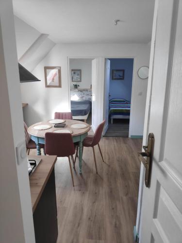 une cuisine et une salle à manger avec une table et des chaises dans l'établissement Gîte au fil de l eau, à Bricquebec