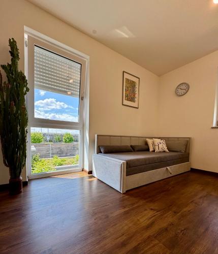 a living room with a couch and a large window at Moderne Wohnung 100 m2 mit Büro und Terrasse in Mühldorf