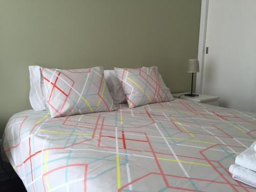 a bed with colorful sheets and pillows on it at Funchal Centrum Apartments - Downtown in Funchal