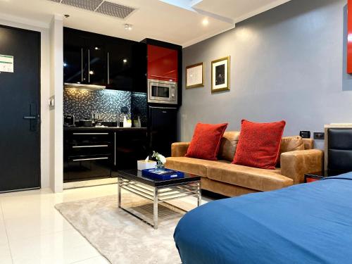 a room with a bed and a couch and a table at Patong - Studio Condo - Absolute Bangla Unit in Patong Beach