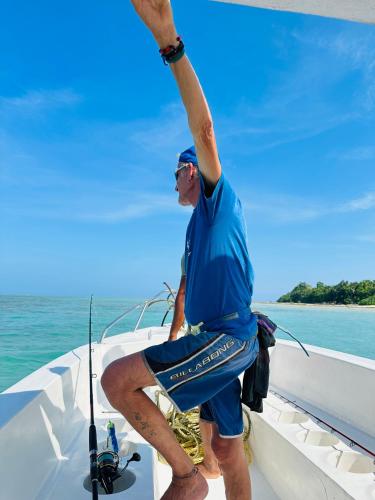 a man standing on the bow of a boat at Roys Villa Havelock in Havelock Island