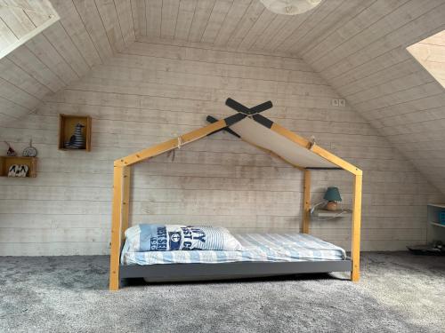 Cette chambre comprend un lit à baldaquin en bois. dans l'établissement La rêverie, à Plouézec