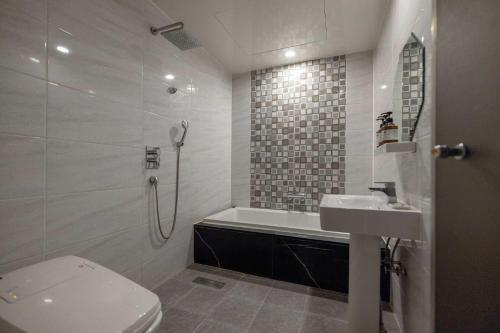 a bathroom with a toilet and a sink and a shower at Hotel Moon Cheonan ShinBuldang in Cheonan