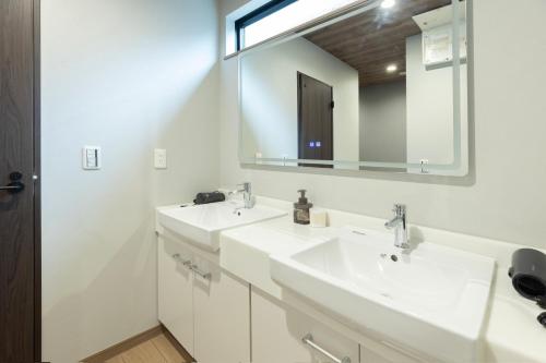 a bathroom with two sinks and a mirror at 新築戸建別荘 M&Z house2 in Fukuoka