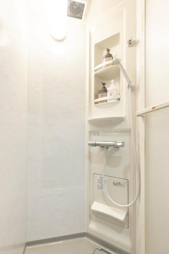 a shower in a white bathroom with a shower at 新築戸建別荘 M&Z house2 in Fukuoka