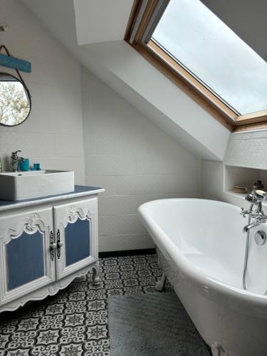 une salle de bain avec une baignoire blanche et un lavabo dans l'établissement La rêverie, à Plouézec