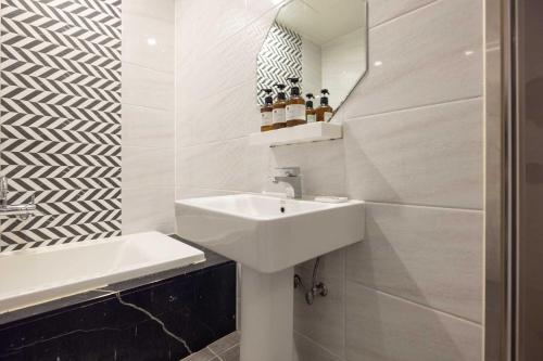 a white bathroom with a sink and a mirror at Hotel Moon Cheonan ShinBuldang in Cheonan