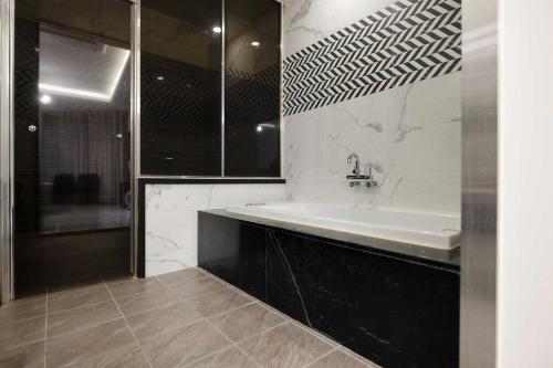 a bathroom with a tub and a sink and a shower at Hotel Moon Cheonan ShinBuldang in Cheonan
