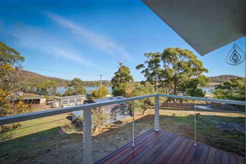 a view from the deck of a house with a balcony at Blossoms on the Bay - 4 Bedrooms in Nubeena