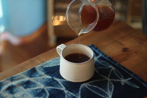 a person pouring coffee into a cup on a table at 藍宿ル1185 in Noda