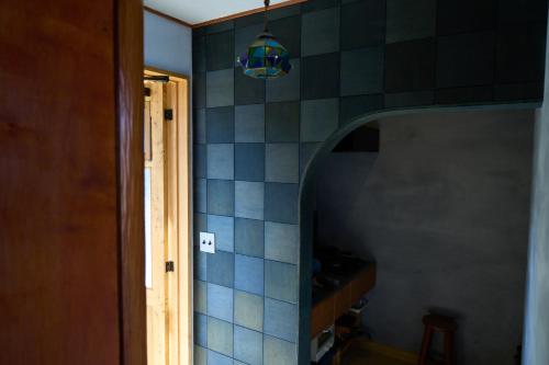 a hallway with a blue tiled wall with a light at 藍宿ル1185 in Noda