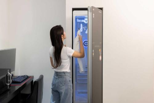 a woman is standing in front of a refrigerator at Hotel Moon Cheonan ShinBuldang in Cheonan