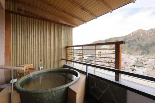 a large bath tub in a room with a window at Hotel Futaba in Yuzawa